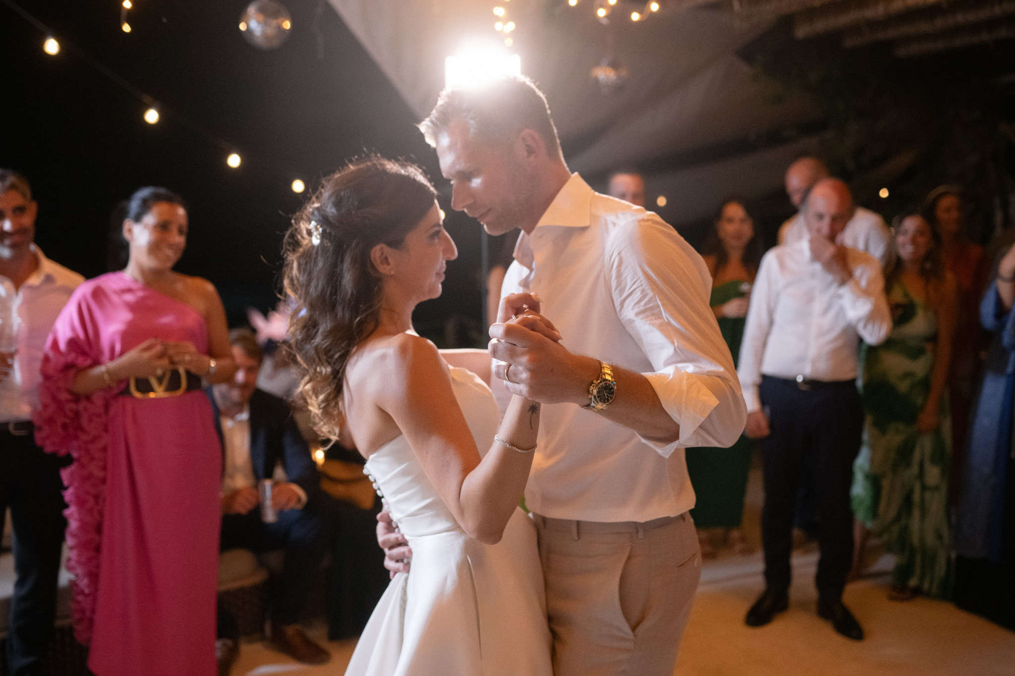Martina and Justin share a first dance as their guests watch at the Mykonos wedding reception.