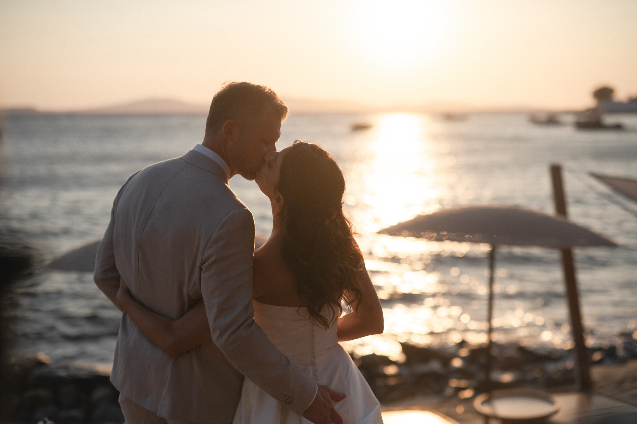 Martina and Justin share a kiss at sunset beside the Aegean in Mykonos.