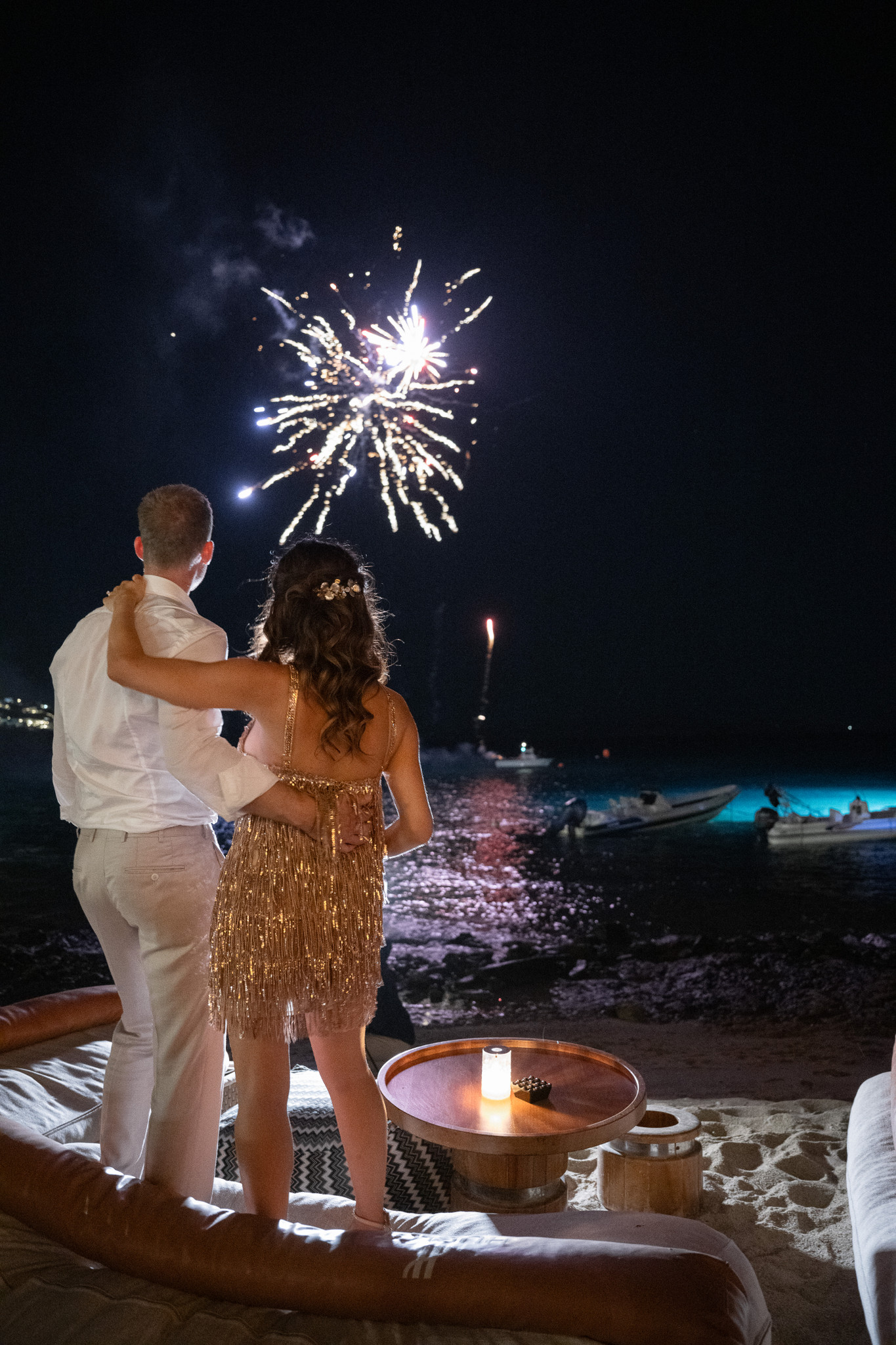 Martina and Justin watch fireworks over the sea during their Mykonos wedding celebration.