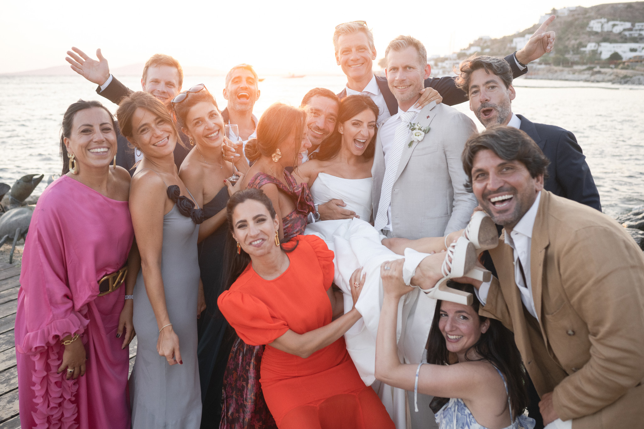 Martina and Justin surrounded by friends and family at their Mykonos wedding by the water.