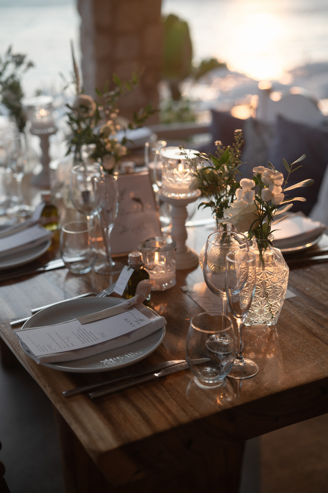 Candlelit wedding table with flowers, glassware and place settings by the sea in Mykonos.