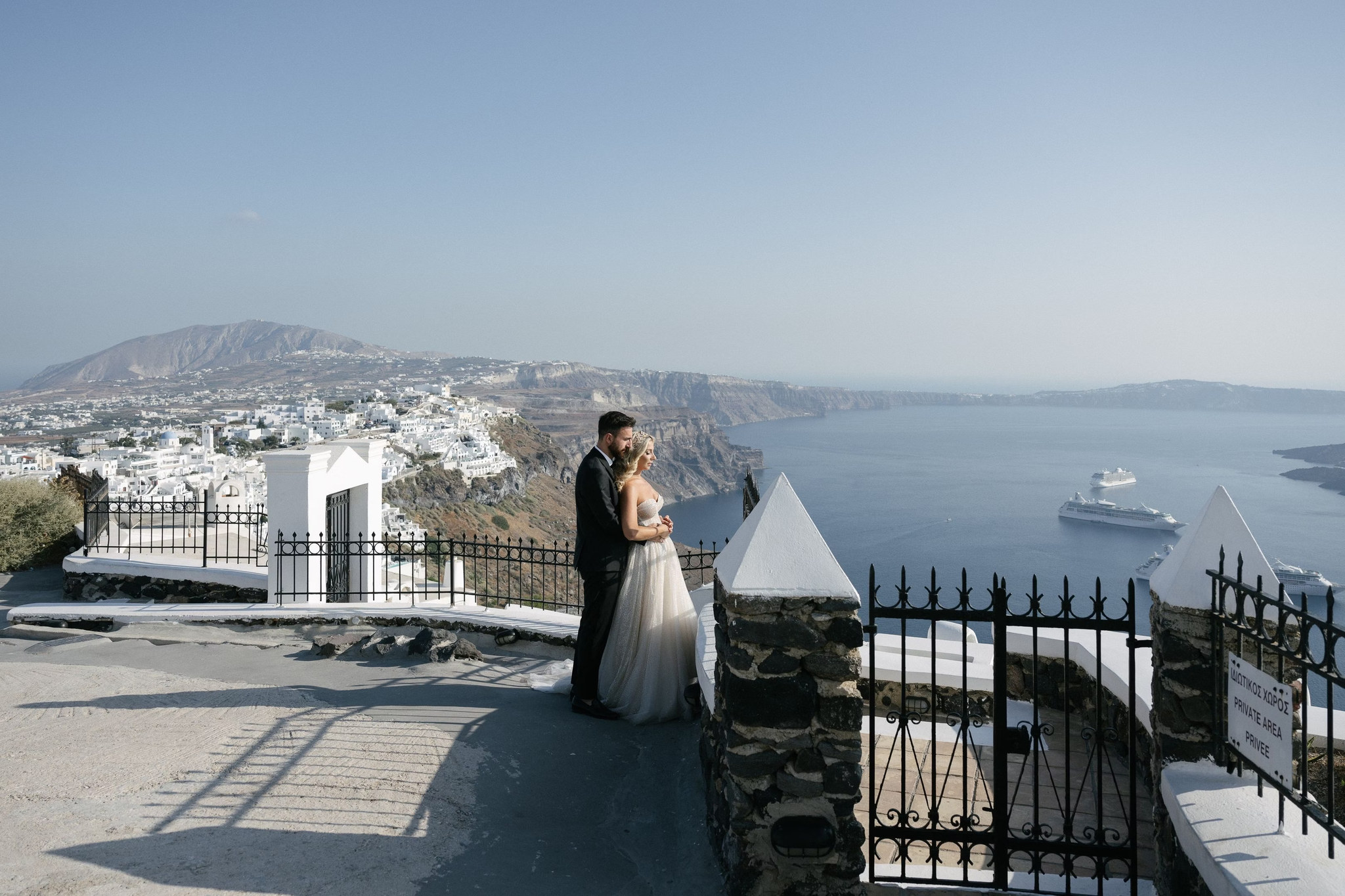 Margi and Nikos together above the Santorini caldera during their couple portrait session